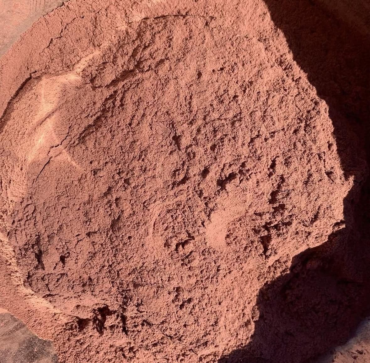 Mimosa hostilis root bark powder, fine and red-brown, seen close up